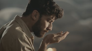 Hombre oliendo granos de café en sus manos